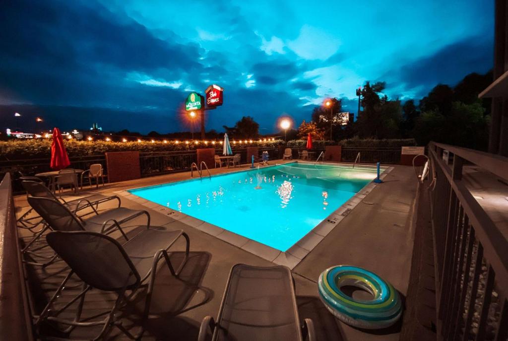 a swimming pool at night with chairs around it at La Quinta by Wyndham Festus - St. Louis South in Festus