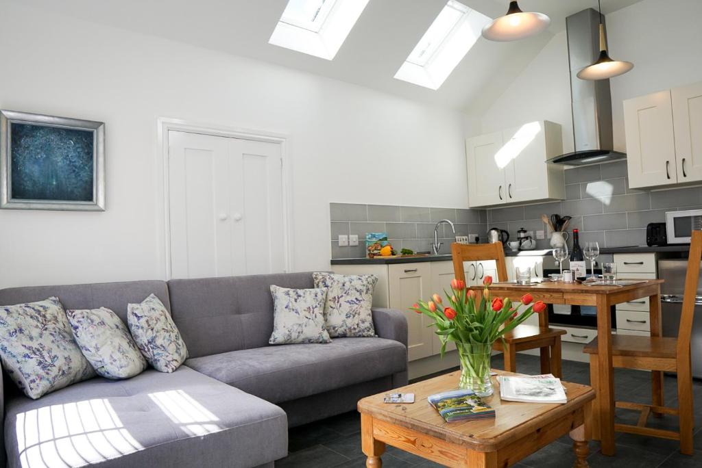 a living room with a couch and a table at The Annex, Tregoddick Barn in Penzance