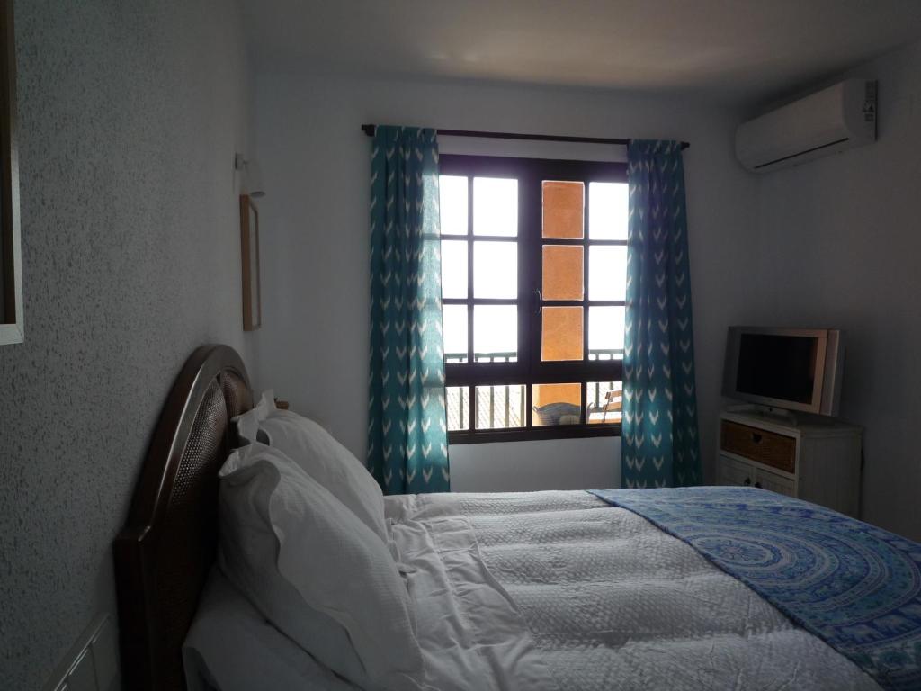 un dormitorio con una cama y una ventana en Can Mascarat, en Altea