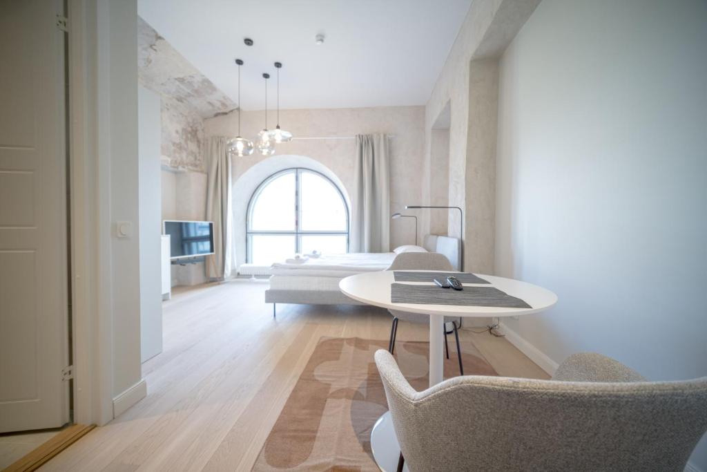 Habitación con cama, mesa y sillas. en Baltic Accommodation - Urban Studio Apartment, en Tallin