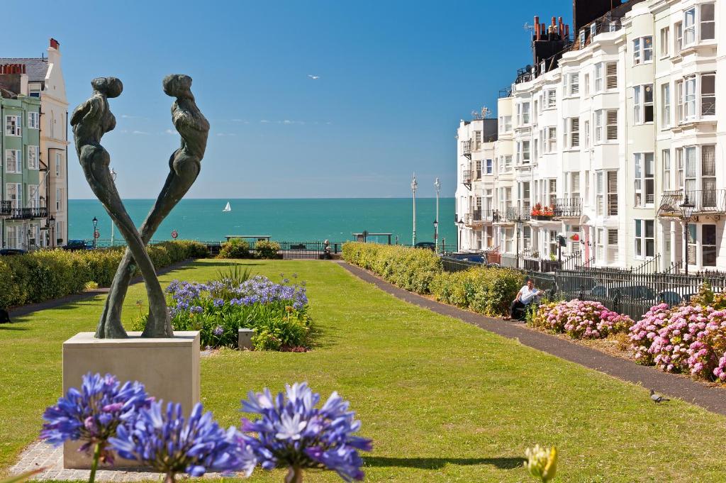 a statue of two people in a park with flowers at Hamptons Brighton in Brighton & Hove