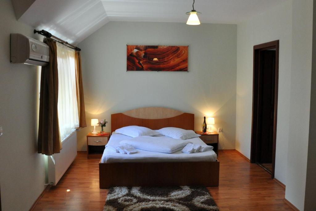 sypialnia z łóżkiem i obrazem na ścianie w obiekcie Pensiunea Central w mieście Reghin