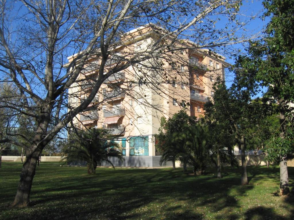 ein Gebäude mit vielen Bäumen davor in der Unterkunft Duplex junto a un Parque in Tortosa
