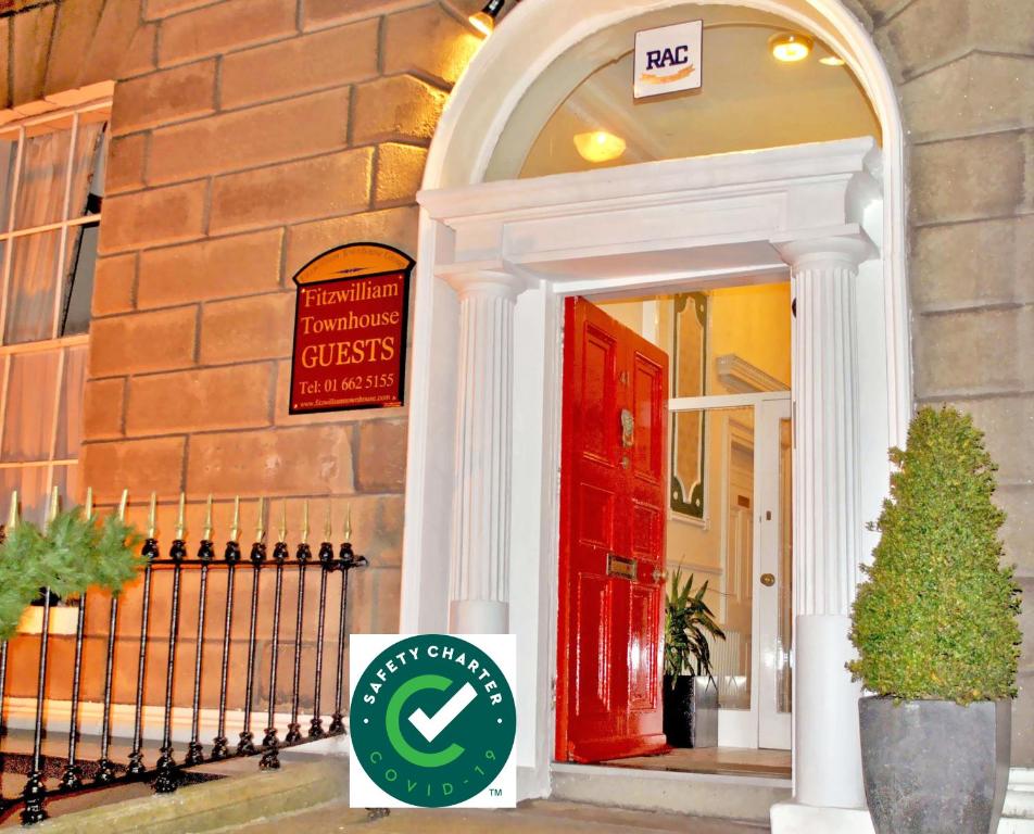 um sinal em frente a um edifício com uma porta vermelha em Fitzwilliam Townhouse em Dublin