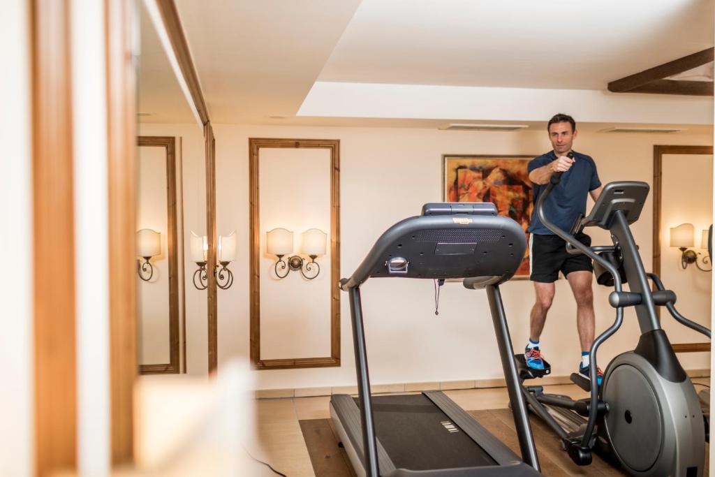 a man standing on a treadmill in a gym at Hotel Genziana in Selva di Val Gardena