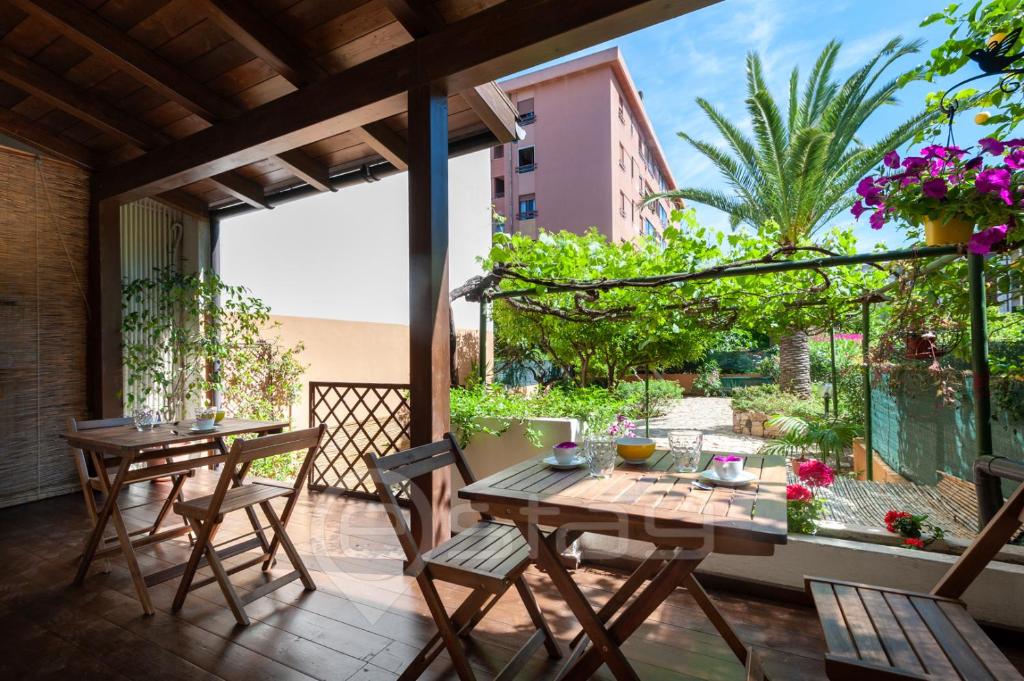 un patio con mesas y sillas y una gran ventana en House Marcella Suites - Near the Beach, en Cagliari