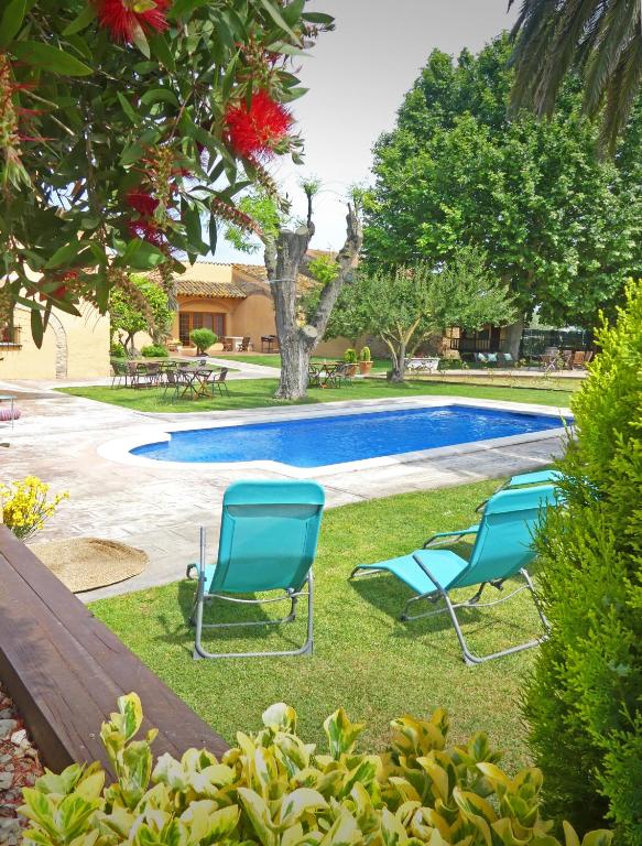 Un grupo de sillas junto a una piscina. en Hotel & Golf Ca La Caputxeta, en Castelló d'Empúries