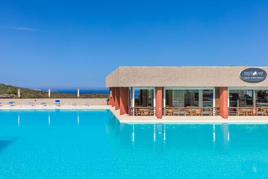 una piscina con acqua blu di fronte a un hotel di Casa vacanze Cugnana Verde a Cugnana Verde