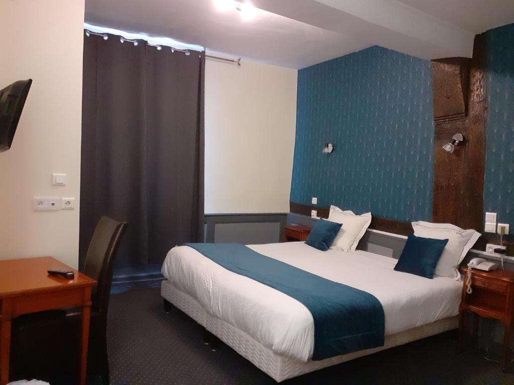 ein Hotelzimmer mit einem Bett mit blauer Wand in der Unterkunft Logis Hôtel Restaurant de l'Ecu in Montbard