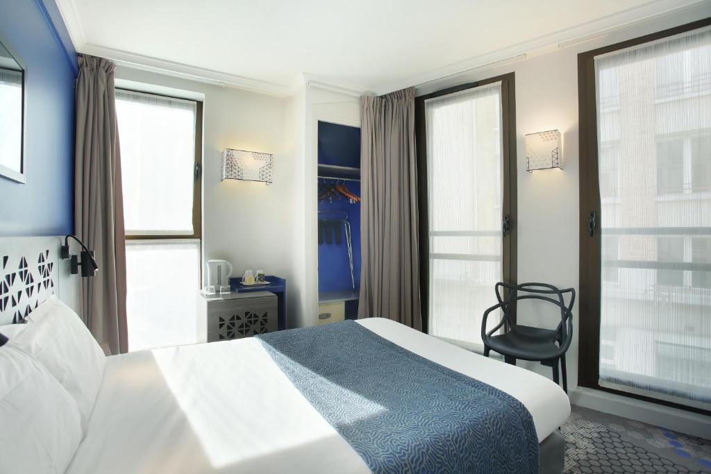 パリにあるホテル エッフェル キャピトルのベッドと椅子付きのホテルルーム