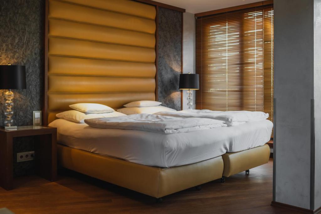 a bedroom with a large bed with a wooden headboard at Yours Truly in Munich