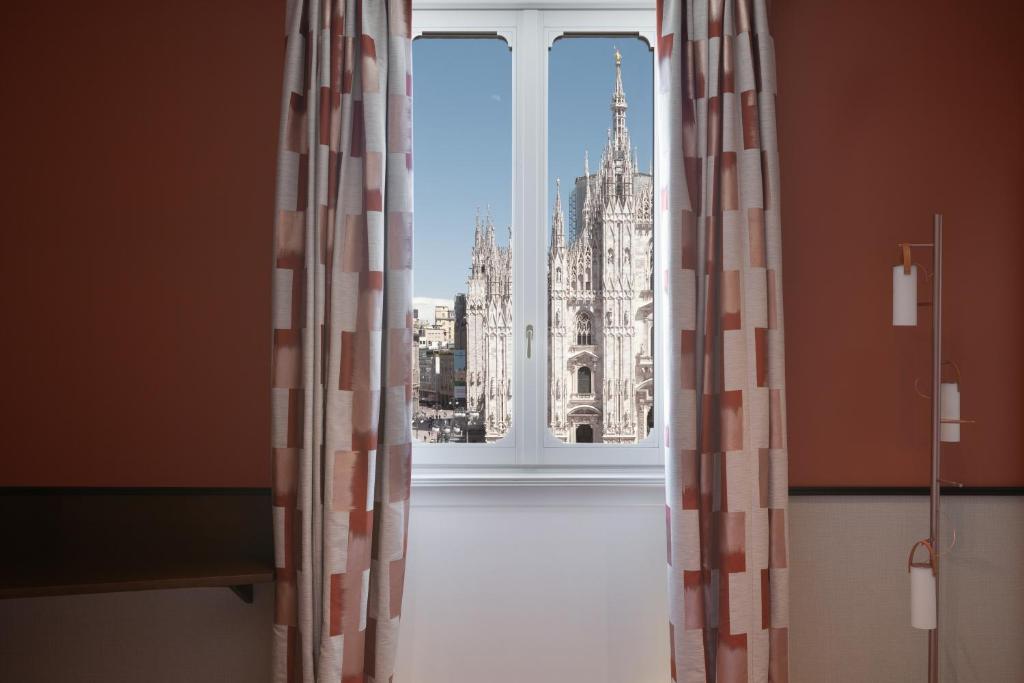 a room with a window with a view of the building at Amabilia Suites in Milan