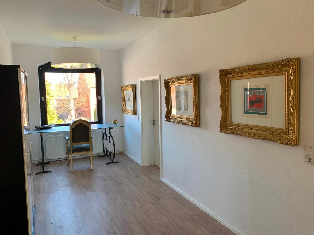 een kamer met een bureau en schilderijen aan de muur bij Etage1 in Hameln