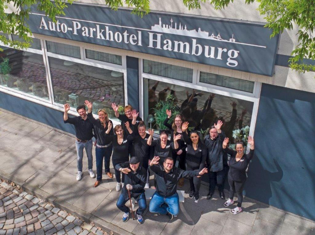 un grupo de personas de pie en frente de un edificio en Auto-Parkhotel, en Hamburgo