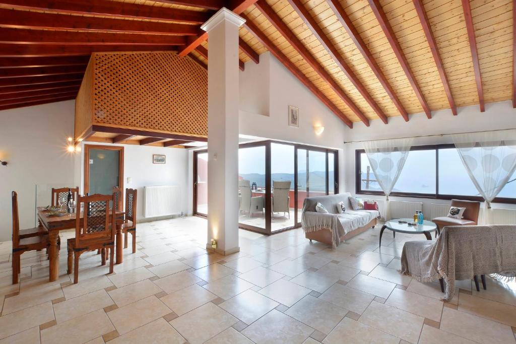 a living room with a wooden ceiling and a table at Golden fox Villa in Lákones