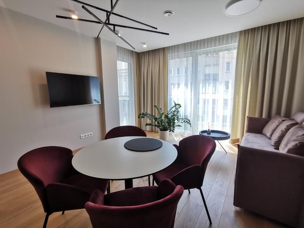 a living room with a table and chairs and a couch at MyCasa CBD in Vilnius