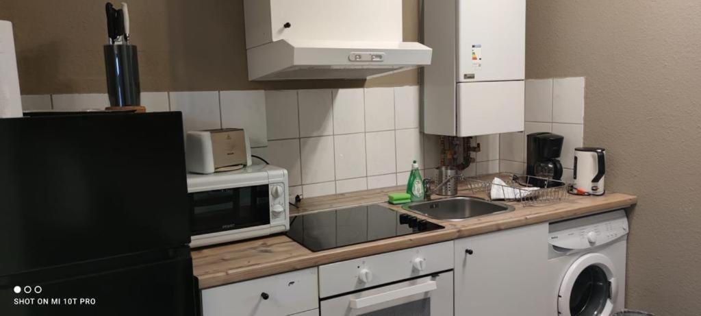 eine Küche mit einer Spüle und einer Mikrowelle in der Unterkunft Apartment Letter in Seelze