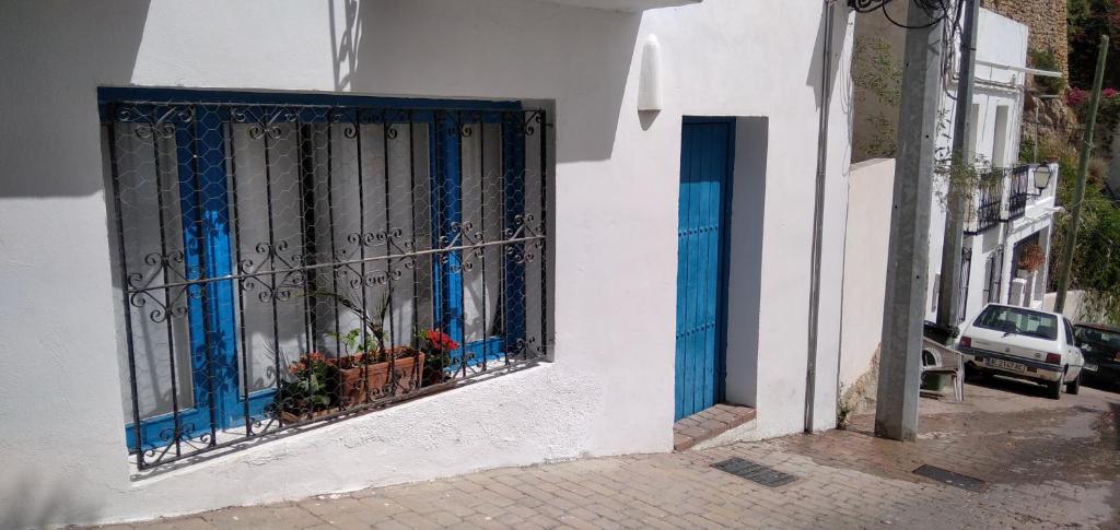 ein weißes Gebäude mit blauen Türen und einem Fenster in der Unterkunft Loft en Mojácar in Mojácar