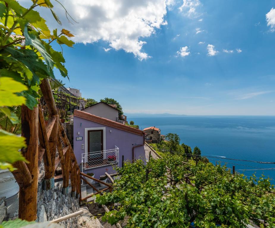 a house on a hill with the ocean in the background at Albergo Diffuso Bacco Furore in Furore