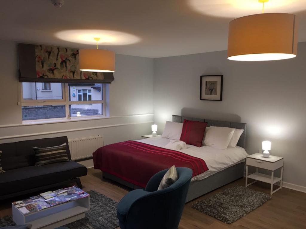 um quarto com uma cama, uma cadeira e um sofá em Hugh O'Neill Ambassador Suite em Dungannon