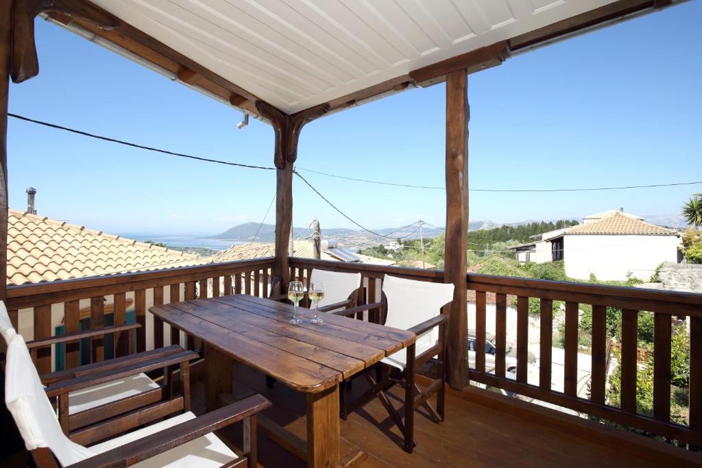 una terraza de madera con mesa y sillas de madera en Stafilos House, en Katouna