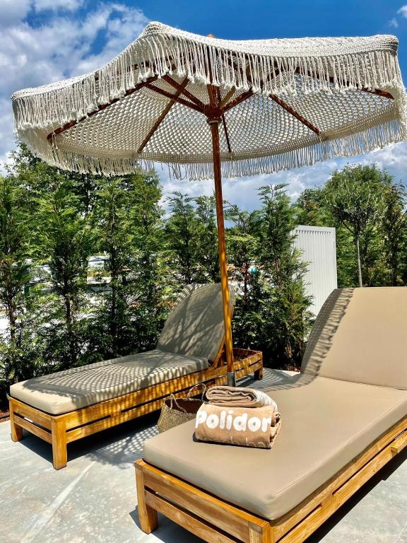 two chairs and an umbrella on a patio at Polidor Camping Resort in Poreč