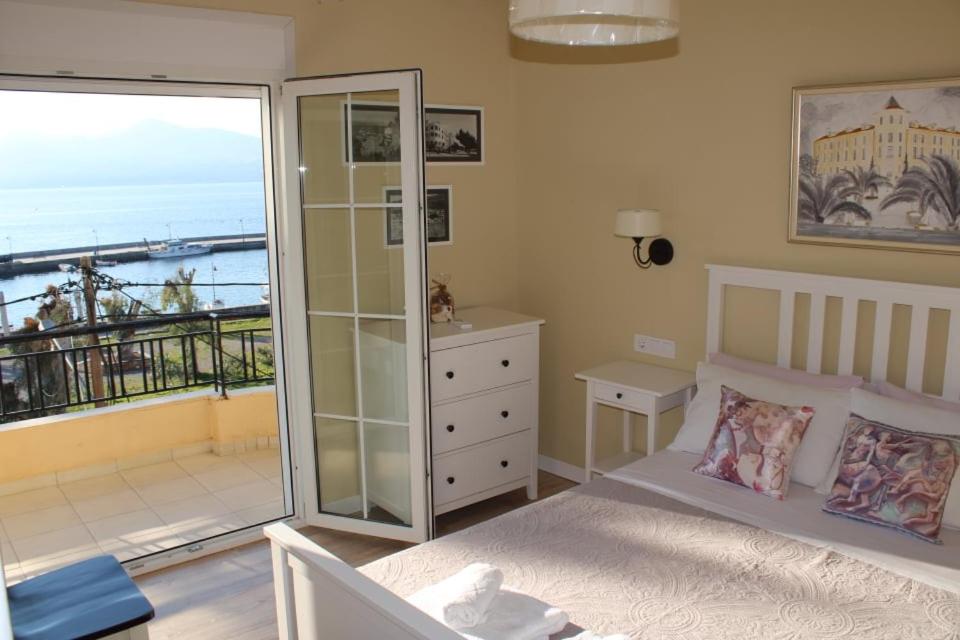 1 dormitorio con 1 cama y balcón con vistas al océano en Studio Tsirigotis Sea view, en Loutra Edipsou