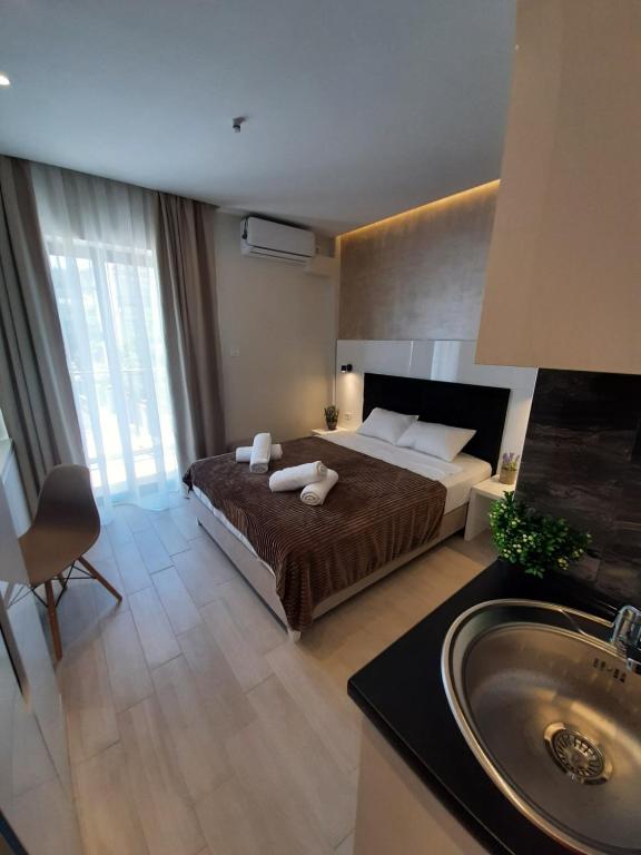 a bedroom with a bed and a sink in it at Grand Agia Triada in Agia Triada
