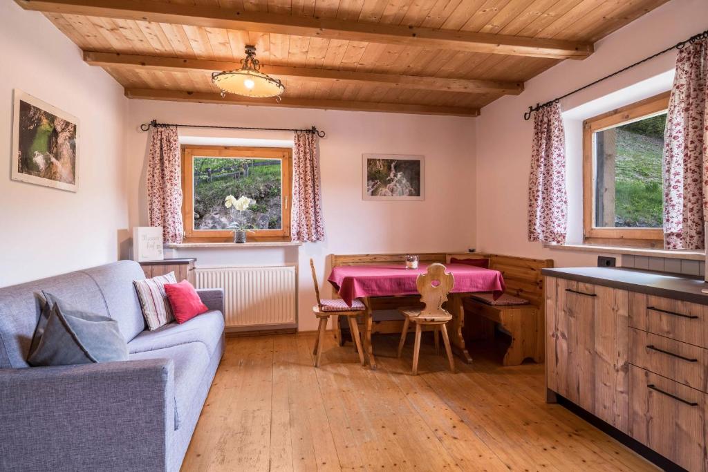 Ferienwohnung Stockrose Nusserhof في أفيلينغو: غرفة معيشة مع طاولة وأريكة