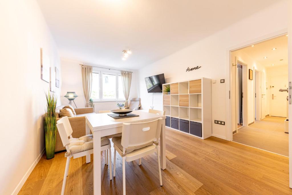 kuchnia i salon ze stołem i krzesłami w obiekcie BRIGHT + CENTRAL near Belvedere by JR City Apartments w Wiedniu