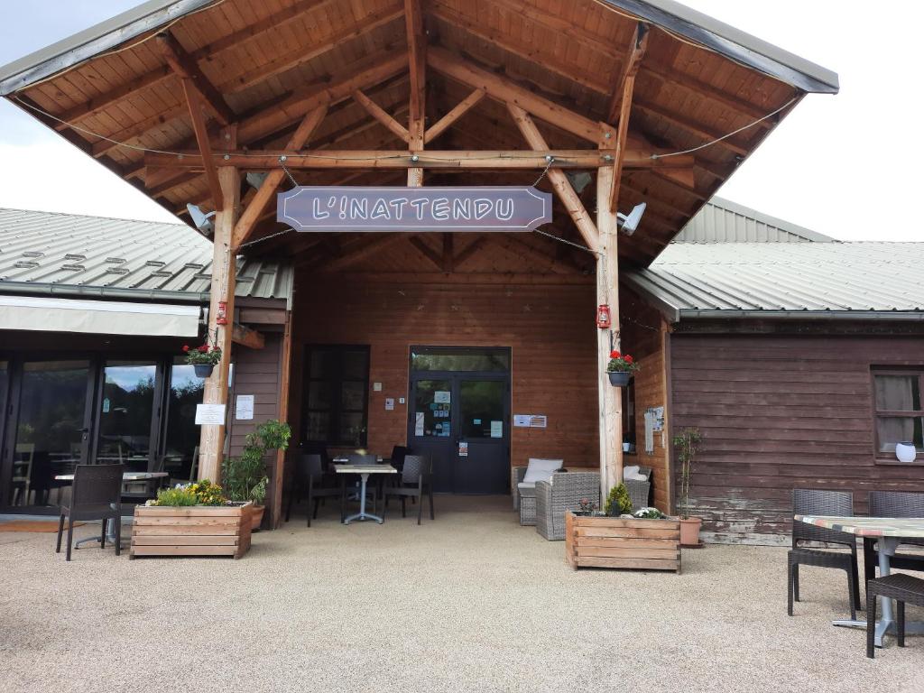 ein Restaurant mit Tischen und Stühlen und ein Schild in der Unterkunft L'Inattendu in Le Vernet