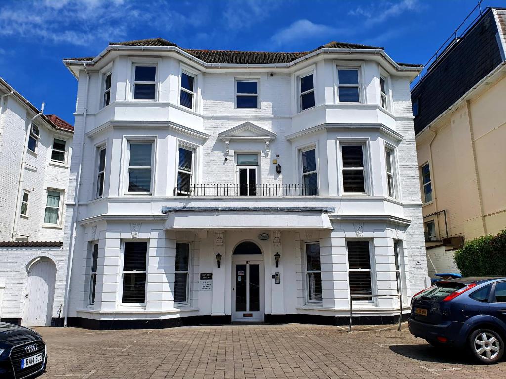 uma casa branca com um carro estacionado em frente dela em Top quality beach front apartment sleep up to 7 guests em Bournemouth