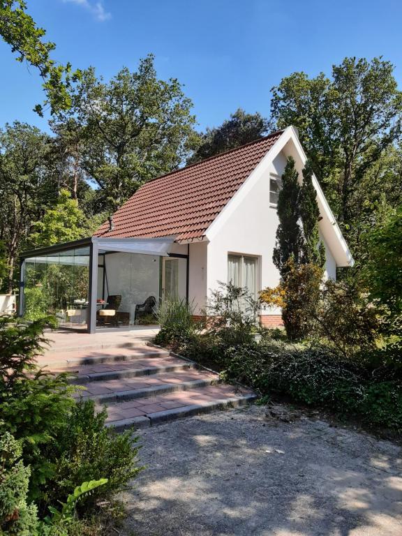 une maison blanche avec une extension en verre dans l'établissement Vakantiewoning Zwaluw Beerze, à Beerze