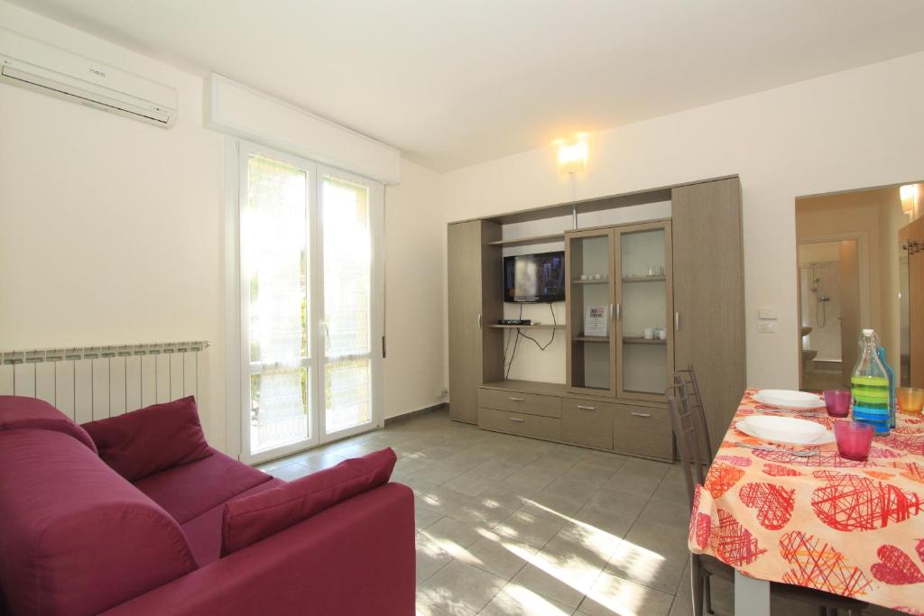 a living room with a red couch and a table at Apartment Pineta 11 in Lido di Pomposa