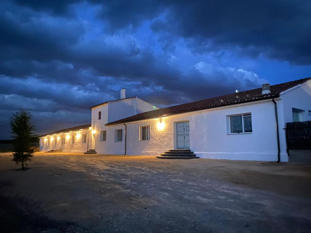 un edificio blanco con luces encendidas por la noche en Entheos en Lerín