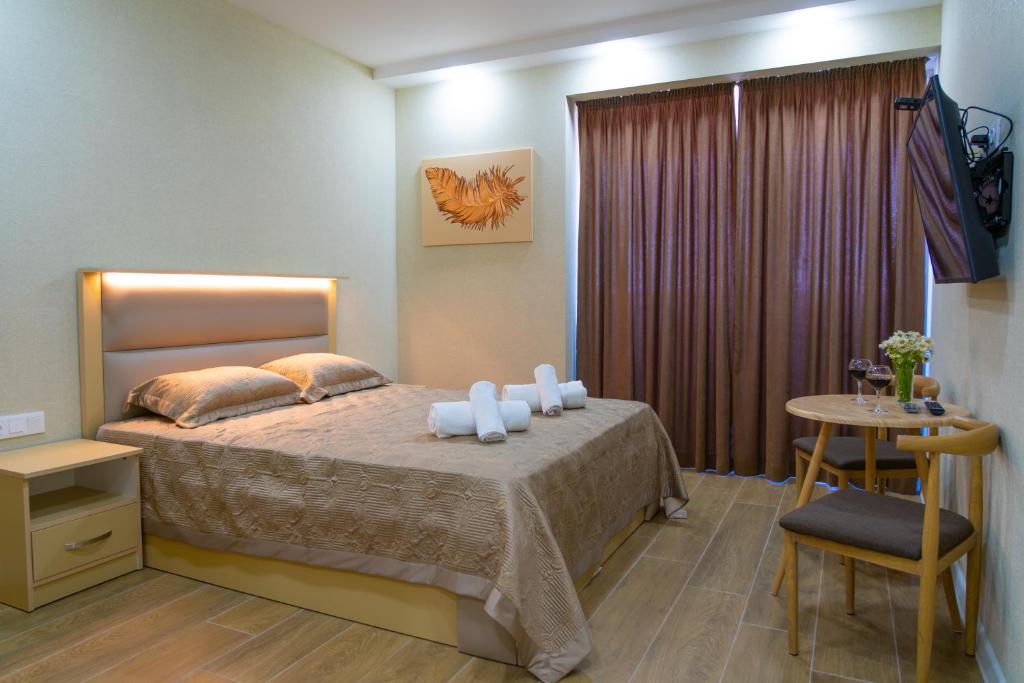 1 dormitorio con 1 cama y 1 mesa con silla en ALLIANCE PALACE GEORGIA BATUMI, en Batumi