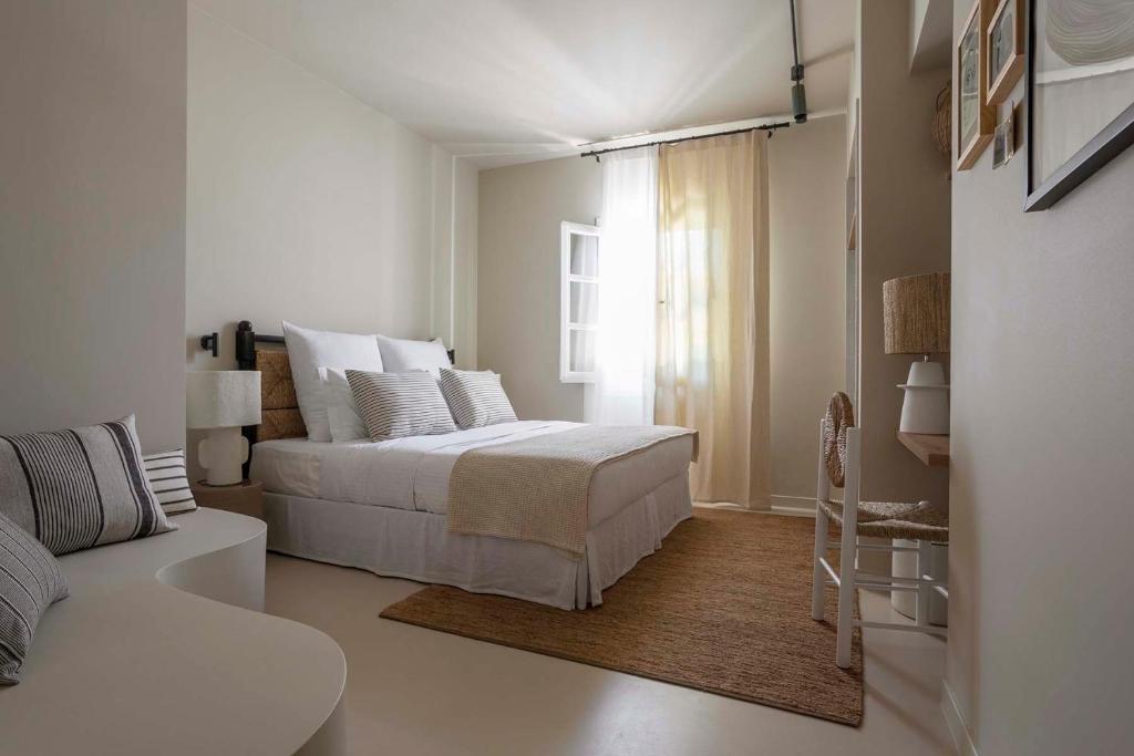 a white bedroom with a bed and a couch at Yayaki Spetses in Spetses