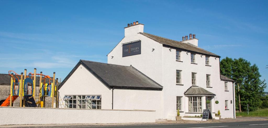 a white building with a playground in front of it at The Tavern at Hale in Milnthorpe