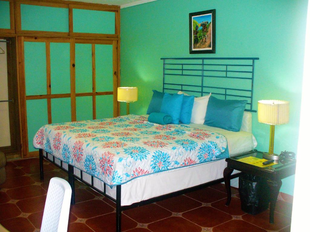a bedroom with a large bed with blue walls at La Cumbre del Pinar Grupo de Alojamiento Turístico in Valle de Ángeles