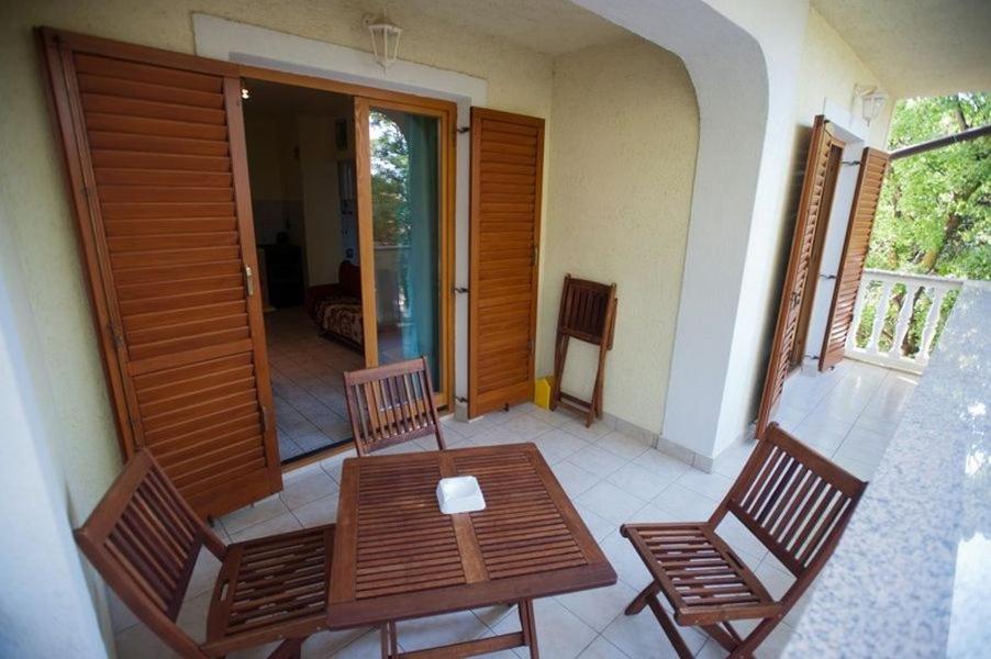 a balcony with a wooden table and two chairs at 2-bedroom Apartment with terrace in Povile 3542-2 in Povile