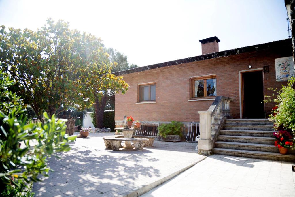 una casa de ladrillo con una escalera que conduce a la puerta en Casa de campo en pelayos, en Pelayos de la Presa