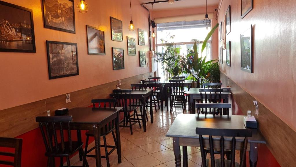 a row of tables and chairs in a restaurant at Pousada - Aqui Hostel in Bragança Paulista