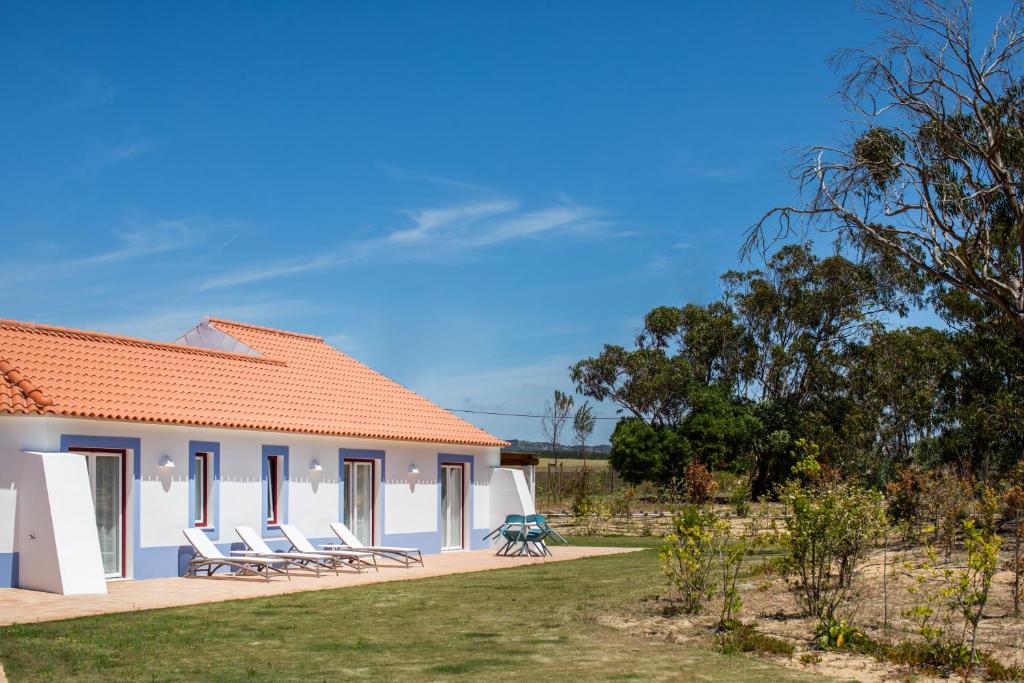 a group of chairs sitting outside of a house at Monte da Bemposta in Porto Covo