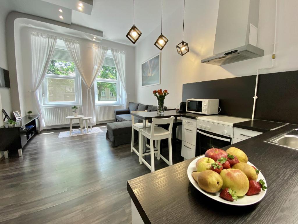 une cuisine et un salon avec une assiette de fruits sur une table dans l'établissement Art Apartment Szeged, à Szeged