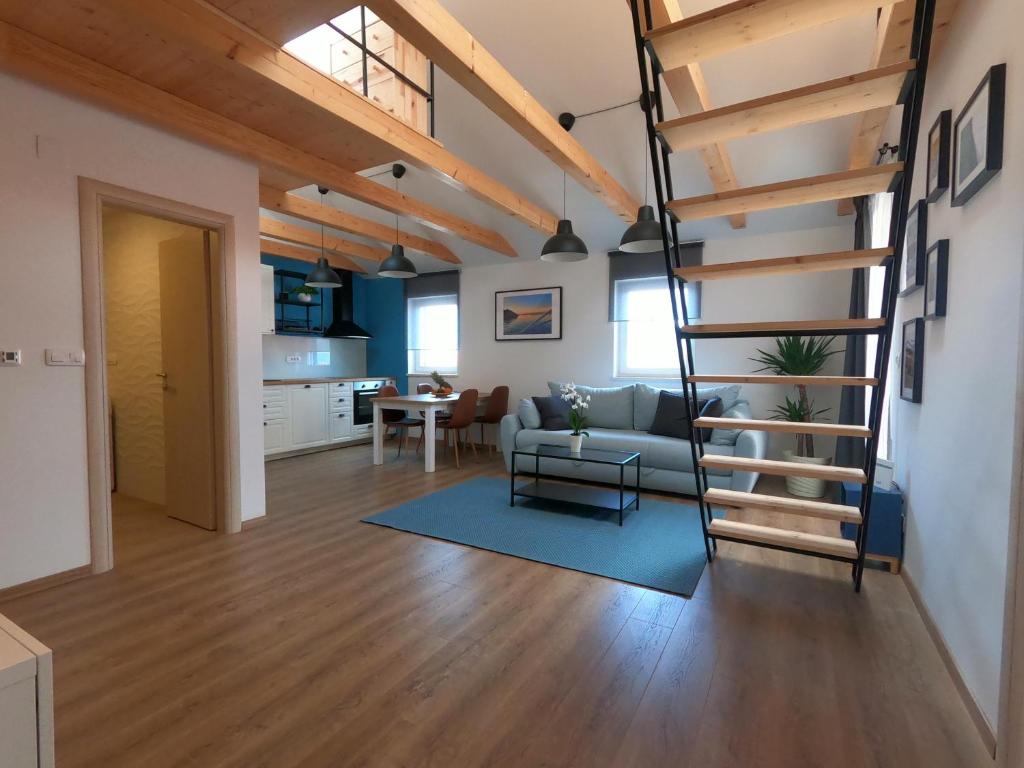 una sala de estar con una escalera en un loft en Gavan Apartment, en Cres