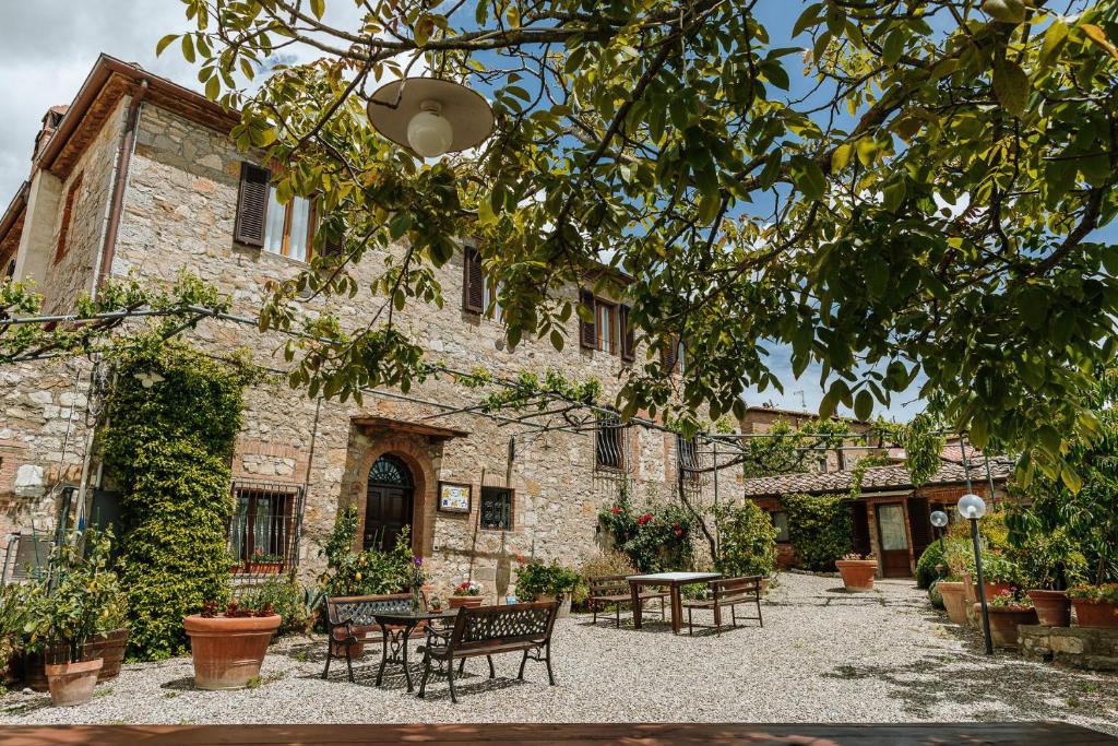 a courtyard with tables and chairs in front of a building at Villa Di Sotto in Castelnuovo Berardenga