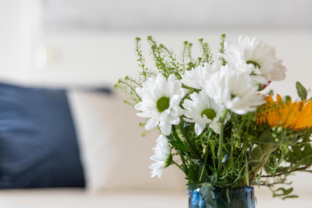 a vase filled with white flowers on a table at Tuomas´ luxurious suites, Rakka in Rovaniemi