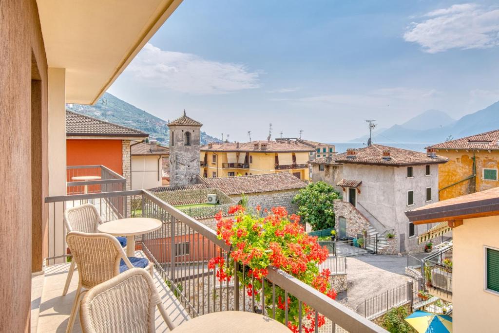 a balcony with chairs and a table and flowers at La Sensa Apartments in Brenzone sul Garda