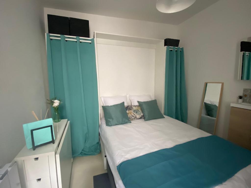 - une chambre dotée d'un lit avec des rideaux bleus dans l'établissement Paris- Opéra Bastille, à Paris