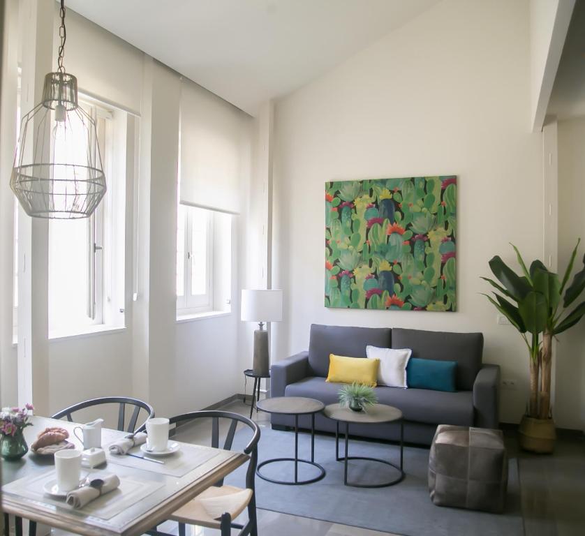uma sala de estar com um sofá e uma mesa em Casa Chinitas Holiday Homes em Málaga
